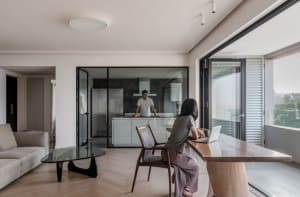 A modern residential kitchen featuring glass and concrete materials.
