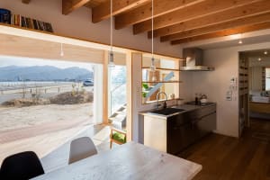 Modern residential kitchen featuring wooden elements and a view of the beach.
