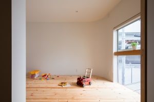 A modern playroom interior with a toy cabinet on a wooden floor near a large window.