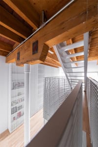 An image showcasing a modern loft interior with wooden beams and metal railings.