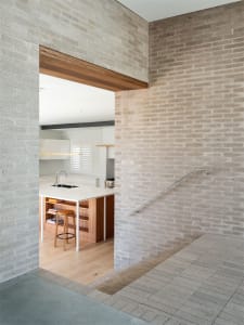 Modern kitchen with wood floor and white countertops.