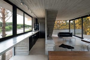 Modern residential interior with concrete walls, glass windows, and minimalist design.