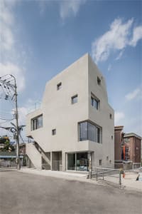 Modern building with smooth concrete exterior and large glass windows.