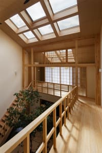 Modern hallway with glass skylights and wooden flooring and railings.
