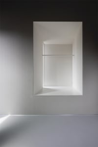 Modern bathroom with minimalist design, featuring concrete walls and floor.