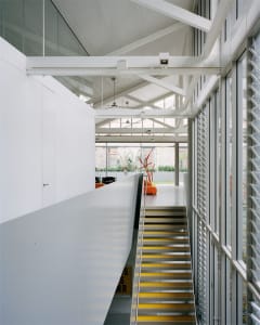 Modern interior with a staircase featuring glass and concrete materials.