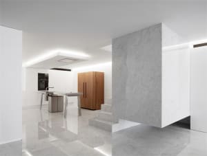 A modern residential kitchen featuring marble countertops and wooden cabinets.