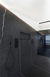 Modern marble bathroom with sleek black fixtures and minimalistic design elements.