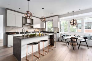 A modern residential kitchen with black countertops and white cabinets.