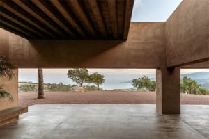 An open, minimalist patio with concrete flooring and a clear view of the natural surroundings.