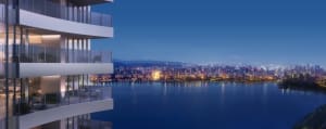Modern residential apartments with glass balconies overlooking a cityscape at night.