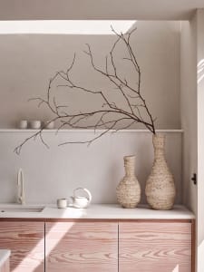 Modern kitchen with scallop-patterned cabinets and organic vases.