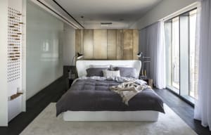 Modern bedroom with a white bed, brown metal headboard, and natural fiber bedding.