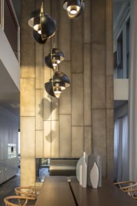 Modern dining room with metallic textured wall and hanging light fixtures