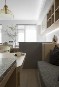A modern minimalist kitchen with marble countertops and glass cabinets.