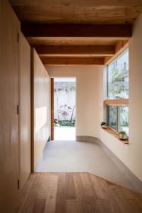 Modern entryway featuring wooden flooring and concrete walls.