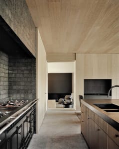 A modern residential kitchen featuring wooden cabinets and a sleek black countertop.