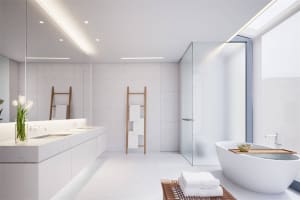 A modern minimalist bathroom with marble walls, a freestanding bathtub, and a double sink vanity.