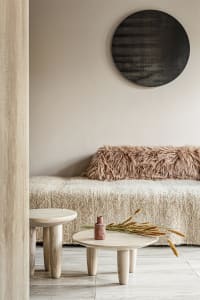 A minimalist living room with wooden furniture on a white wooden floor.