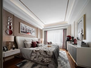 A modern bedroom with a large bed, white and red pillows, and a fur blanket, surrounded by framed artwork, a white dresser, a
