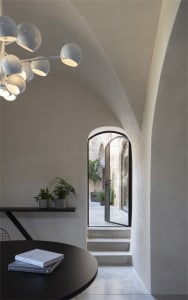 Angular concrete staircase leading to an industrial-style loft with modern furniture and exposed concrete walls.