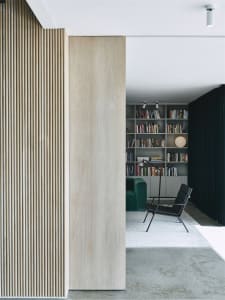 A modern library with wooden paneling and a collection of books on shelves.