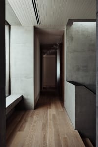 Modern residential interior design featuring concrete and wooden elements.