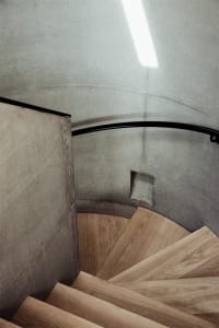 A modern staircase featuring a combination of concrete and wooden steps.