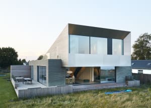 A modern home with a wooden exterior and large glass windows.
