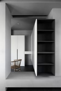 Modern interior design featuring a minimalist space with concrete walls and wooden furniture.