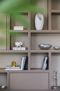 A minimalist bookshelf with ceramic vases and books on display.