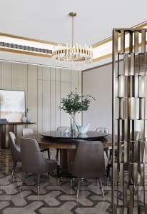 Modern dining room with marble flooring and table, featuring a round dining table surrounded by brown leather chairs, and a c