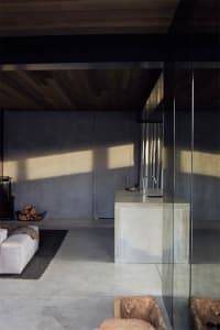 A modern industrial kitchen featuring a concrete kitchen island with a minimalist design, characterized by clean lines, expos