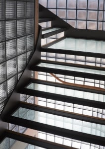 An industrial-style staircase with glass blocks and metal railings.