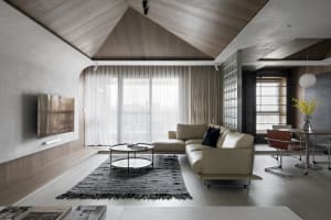 A modern, minimalist living room with concrete aggregate floors and walls, featuring a comfortable sofa, coffee table, and la
