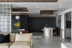 A modern living room with a glass window, wooden furniture, and a concrete floor.