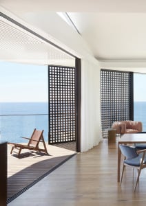 Modern residential interior featuring a sea view, wooden flooring, and contemporary furniture.