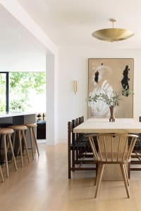 Modern minimalist dining room featuring wood and metal furniture.