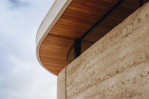Modern building exterior featuring concrete panels and a wooden roof