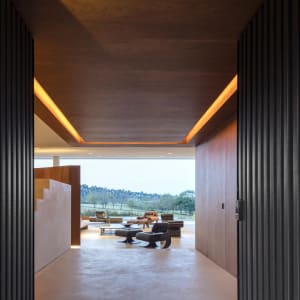 A modern living room featuring minimalist furniture and concrete flooring and walls.