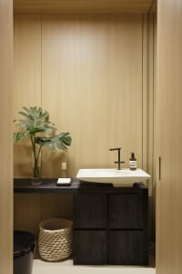 A modern bathroom featuring black wood cabinetry and marble countertop with a sleek, rectangular sink.