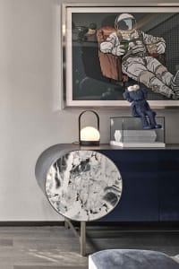Modern living room with marble coffee table and metallic accents, featuring an astronaut-themed artwork on the wall.