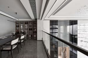 A modern workspace featuring wooden desks, glass partitions, and marble finishes.