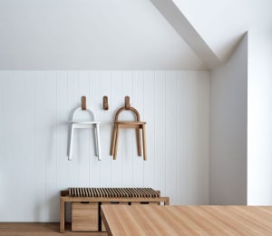Minimalist interior with wooden furniture hanging on the wall and a wooden bench and table.
