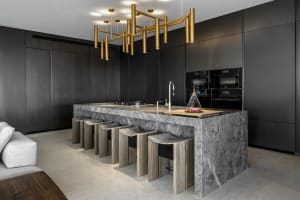 A modern, minimalist residential kitchen featuring a marble countertop and minimalist design elements.