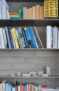 Modern concrete bookshelf displaying organized books.