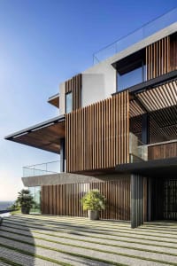 A modern residential building with wooden slats and glass windows.