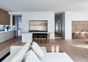 Modern living room and kitchen with open-concept design, featuring wood and marble materials