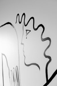 An abstract ink drawing with wavy lines and a face-like profile.