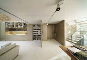 Minimalist living space with white painted floors, concrete walls, and modern furniture.